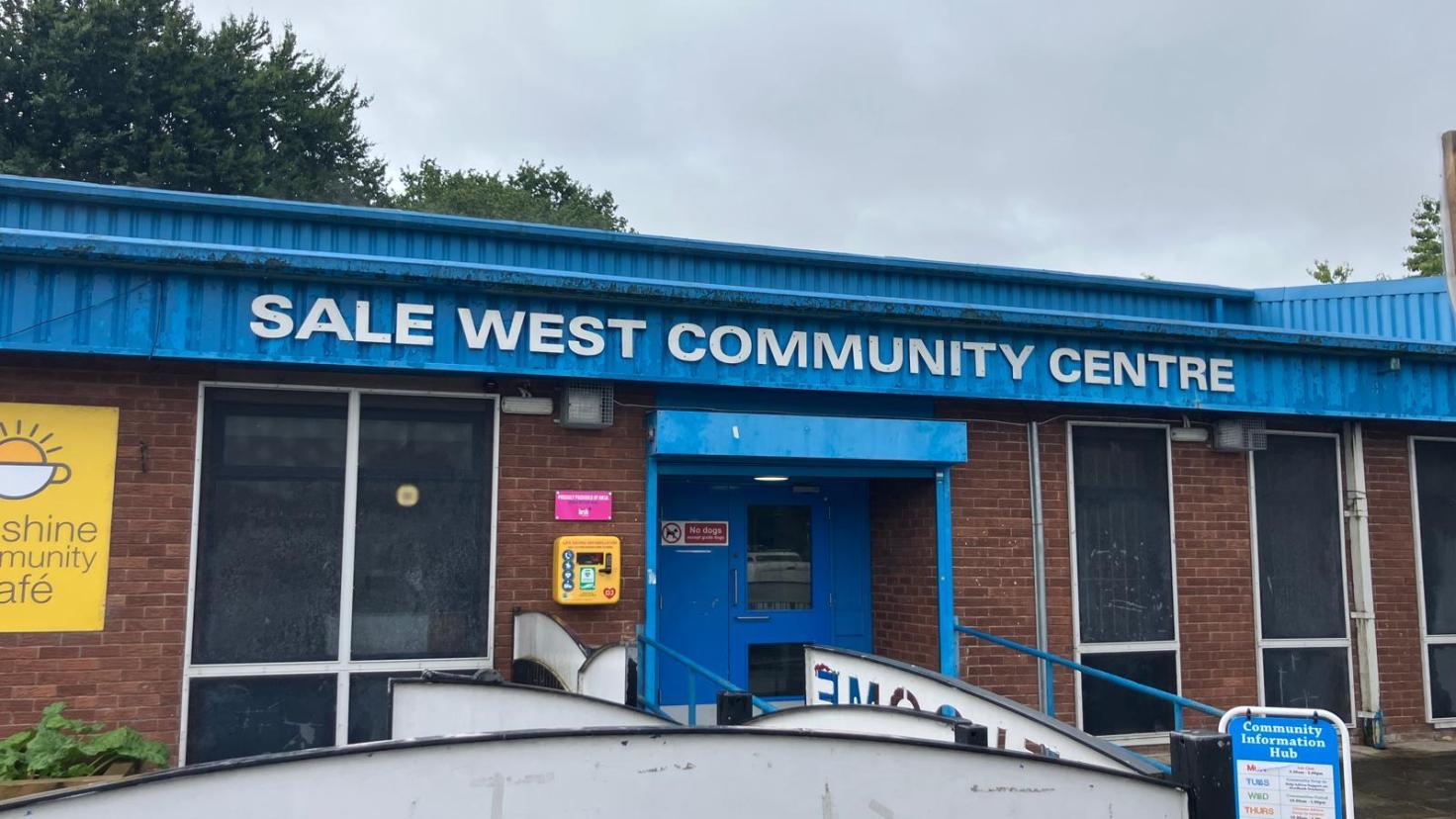 A single-storey building with large windows, and a sign reading 'Sale West Community Centre.'