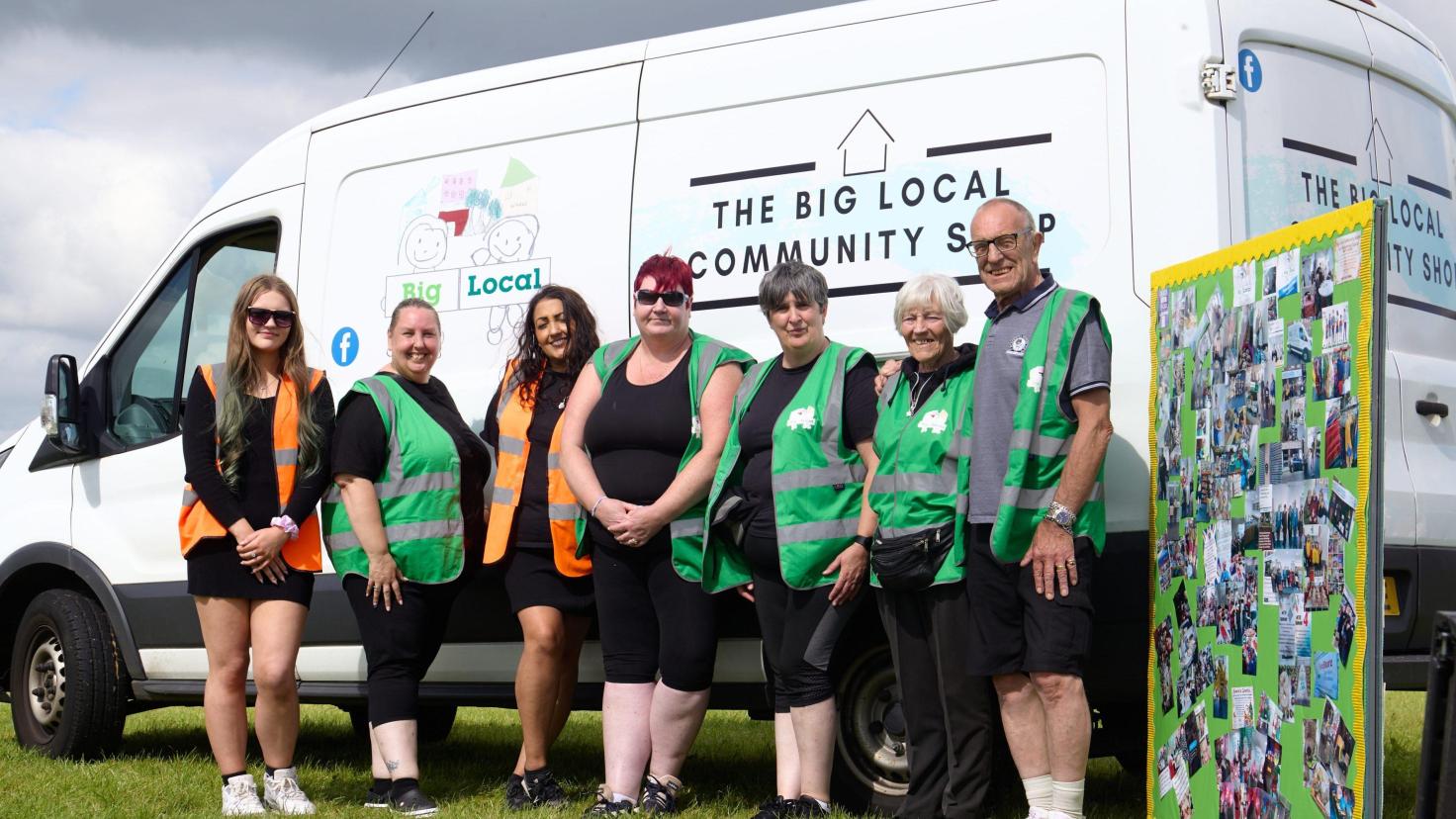 Seven members of the team standing in front of white The Big Local Community Shop van.