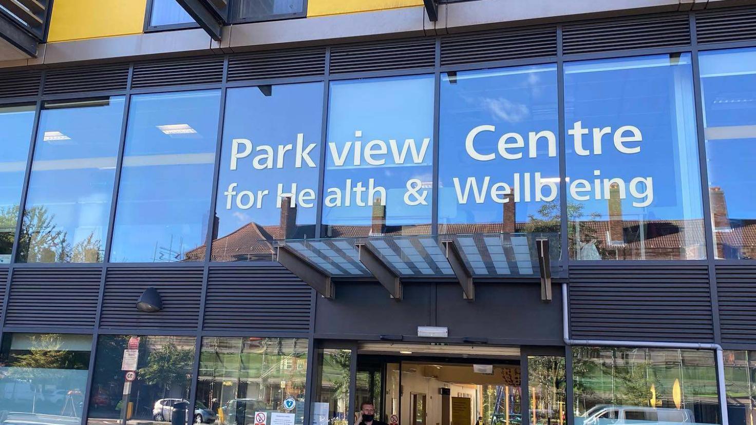 A glass-fronted modern building with 'Parkview Centre for Health & Wellbeing' in white letters over the door.