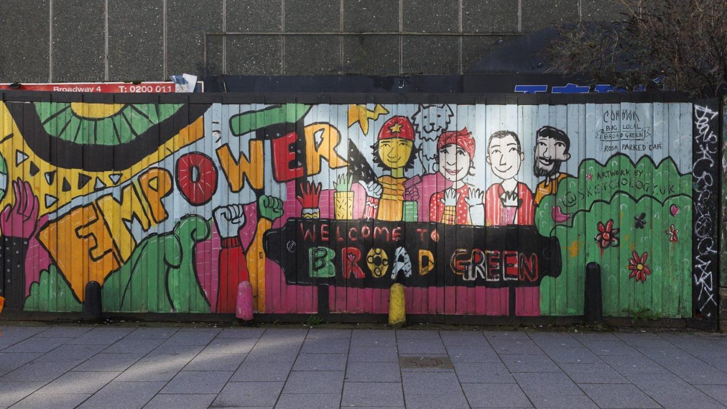 A bold mural on a wall featuring cartoon people and the word 'EMPOWER' in colourful letters.