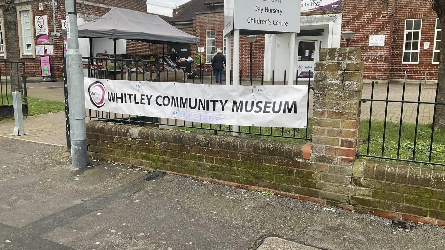 A red-brick building with a banner on railings reading 'Whitley Community Museum'.