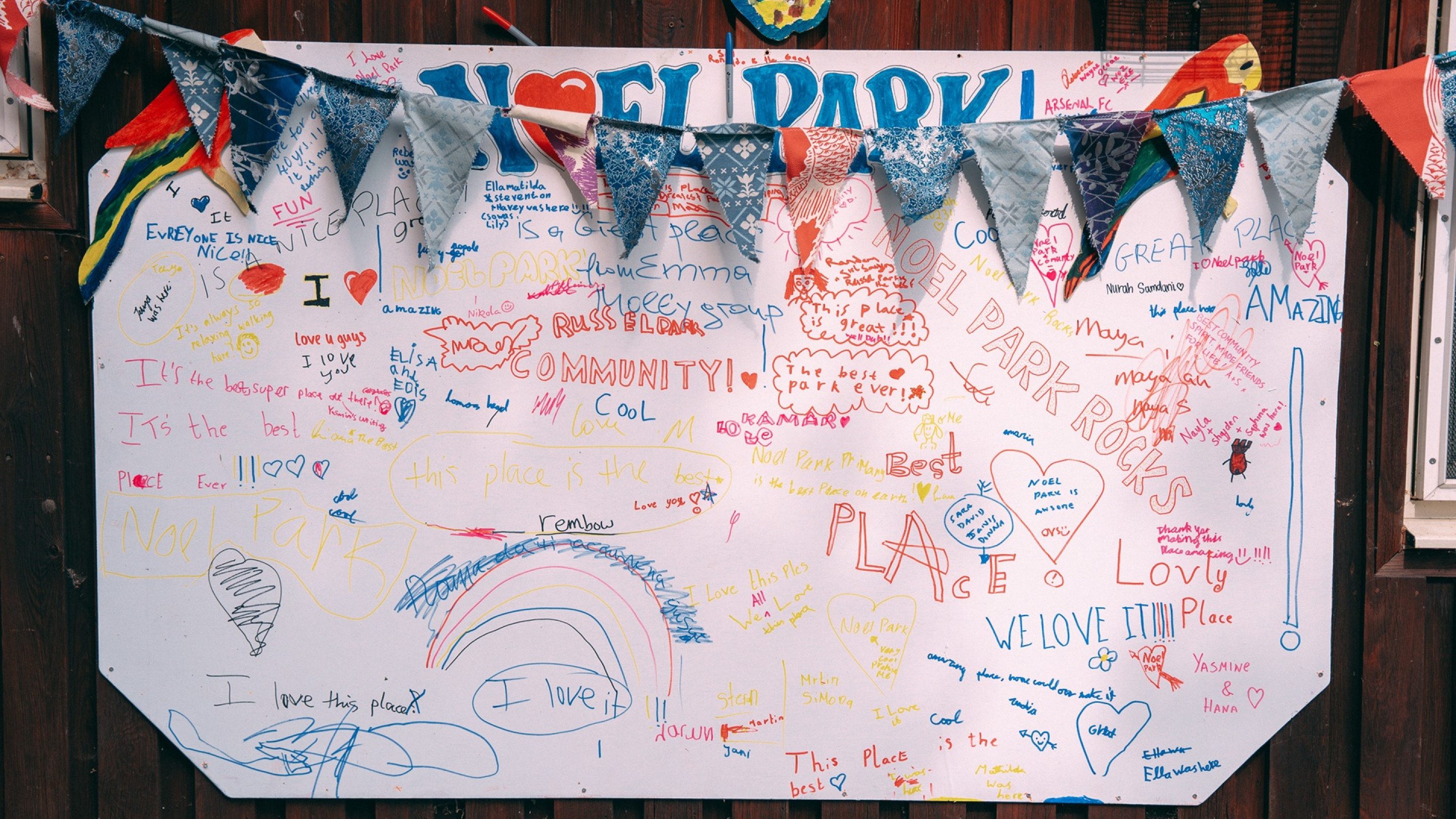 Bunting over a large paper banner covered in drawings and comments written in colourful pen.
