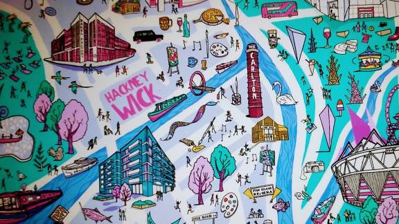 A colourful map mural showing buildings, rivers and green spaces and the words 'Hackney Wick'.