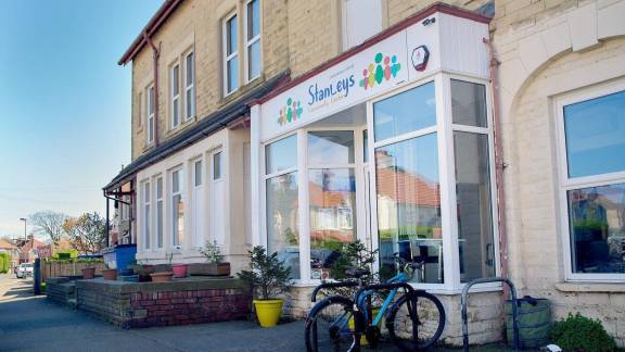 A shop front with bikes outside, and the sign 'Stanleys Community Centre' above the front window.