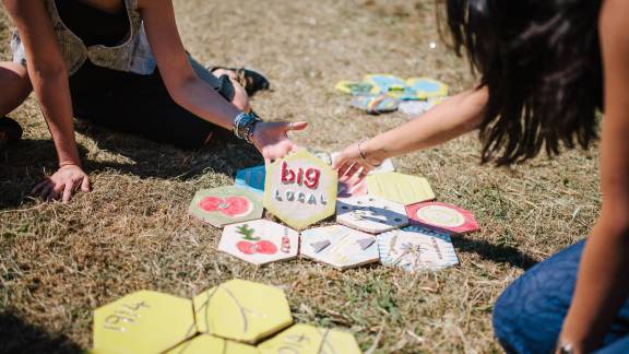 A selection of small hexagonal tiles with two people holding a tile that says 'Big Local'.