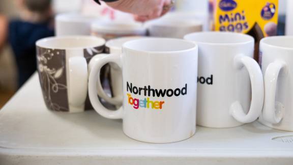 A collection of mugs on display with Northwood Together branding and Easter egg on a table.
