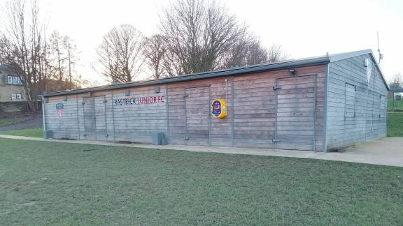 A large wooden building in a field.