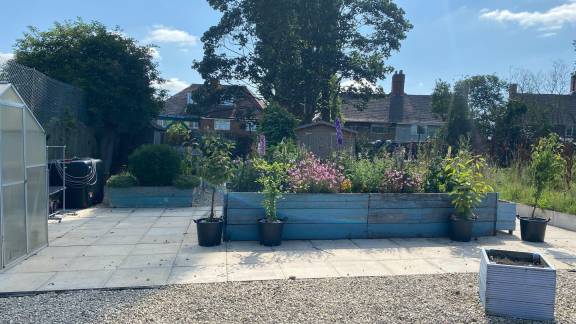 Planted raised beds surrounded by concrete slab walkways.