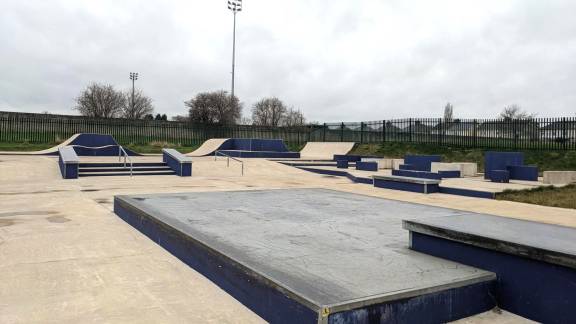 A concrete skatepark with ramps and slopes.