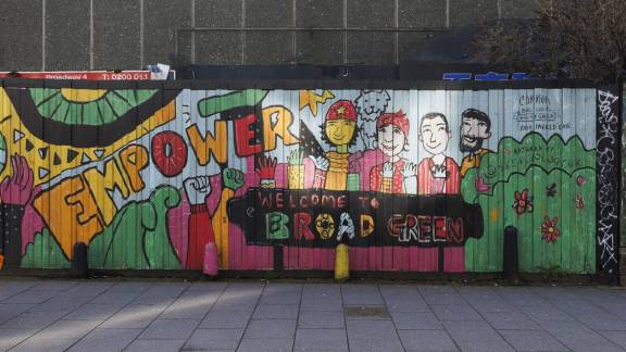 A bold mural on a wall featuring cartoon people and the word 'EMPOWER' in colourful letters.