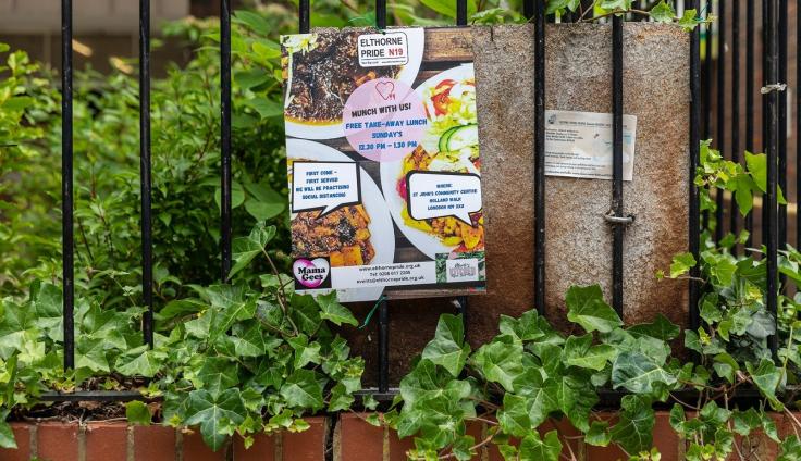 A colourful poster on railings showing food items and advertising food-sharing events.