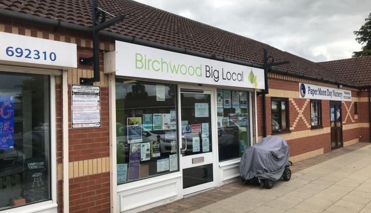 A single-storey row of shops with a sign above one that reads Birchwood Big Local.