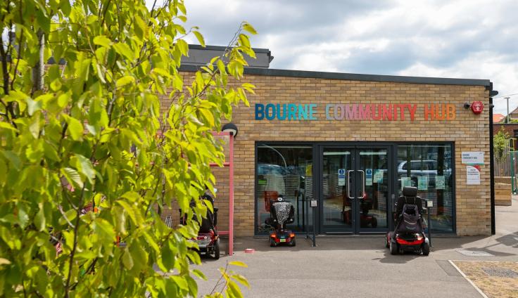 A single-storey brick building with a colourful sign above a wide glass entrance saying 'Bourne Community Hub'.
