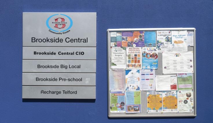 A noticeboard covered with posters advertising activities.