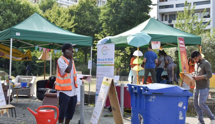 Two pop-up gazebos with a banner reading 'Warm and well'