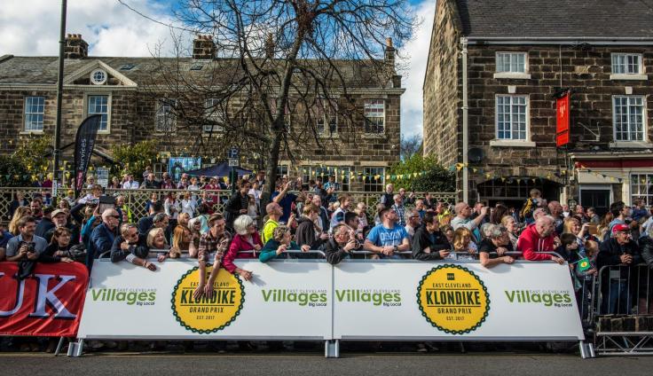 A large crowd of spectators behind a banner reading 'Klondike Grand Prix'.