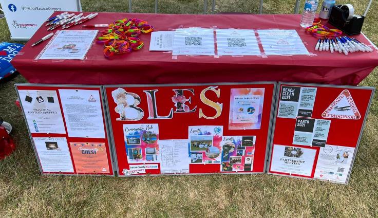 A colourful stall with posters, papers and pens.