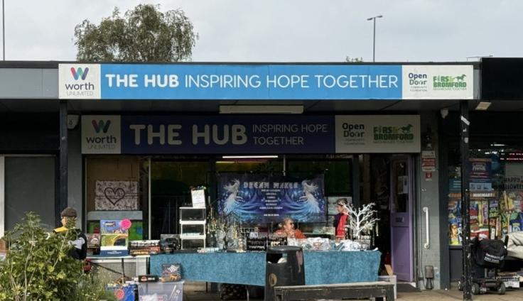 A shop front under a sign reading 'The Hub inspiring hope together'.