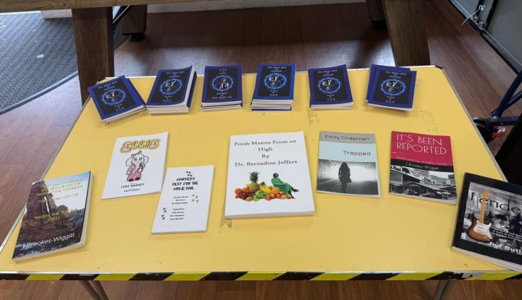 Seven different books laid out on a table.