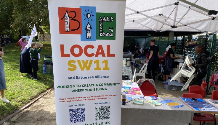 Long white banner reading 'Big Local SW11' providing information next to a stall