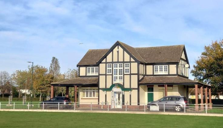Mock Tudor building situated in a green space.