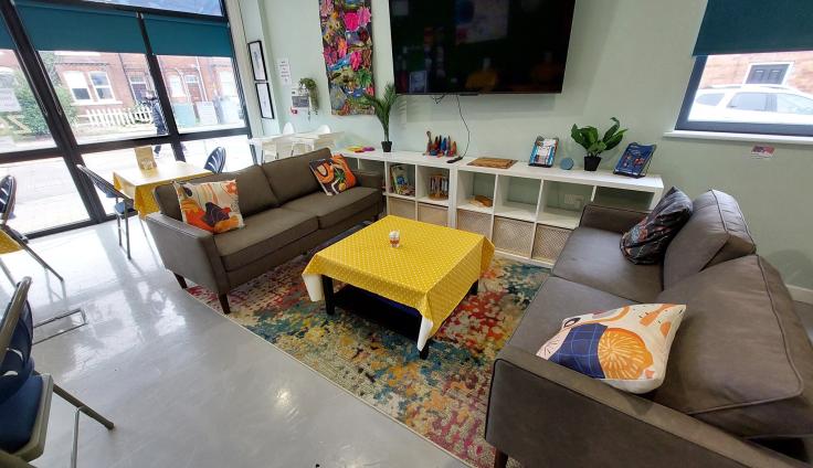A modern interior with large windows and two sofas facing each other with a coffee table in the middle.