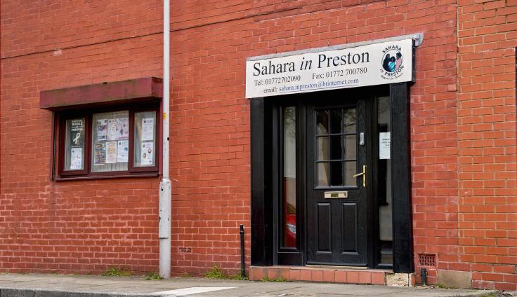 A red-brick building with a doorway under the sign 'Sahara in Preston.'