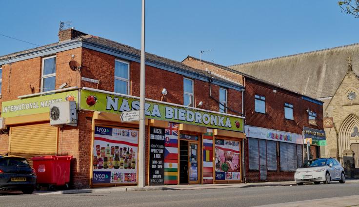 A row of shops with brightly-coloured signage across the front.