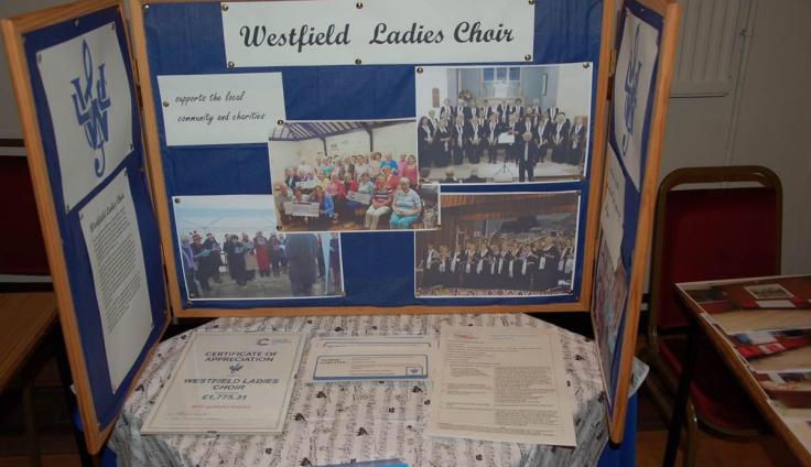 A display stand on a table with photos of a group of women.