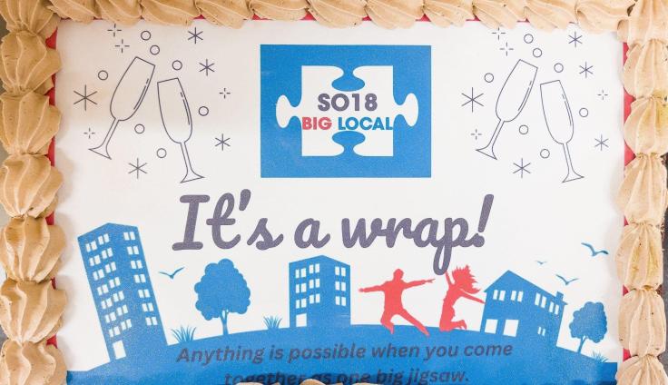 A colourful cake with buttercream piping which says: 'It's a wrap! Anything is possible when you come together as one big jigsaw.'