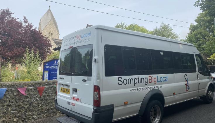 A white minibus with 'Sompting Big Local' livery.