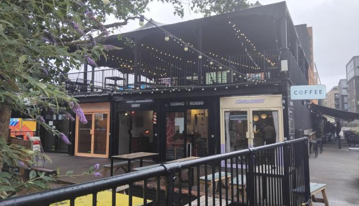 A two-storey building with a roof pergola and outdoor lights.