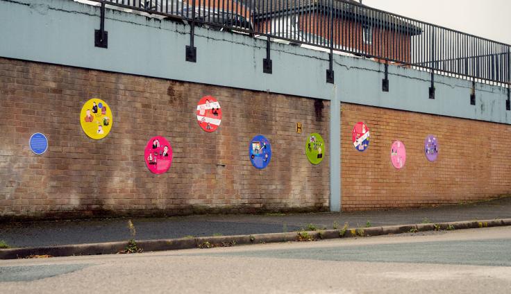 A brick wall with mounted colourful circular plaques