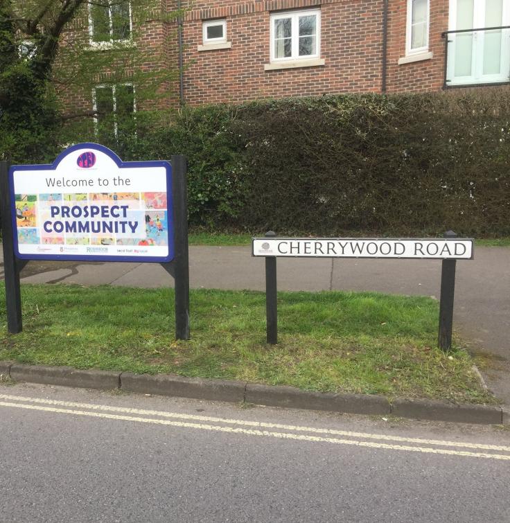 A sign next to a road sign that reads "Welcome to Prospect Community".