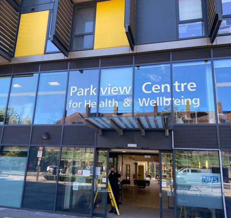 A glass-fronted modern building with 'Parkview Centre for Health & Wellbeing' in white letters over the door.