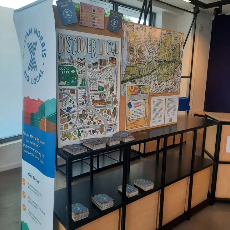 An exhibition stand covered in colourful notices and posters.